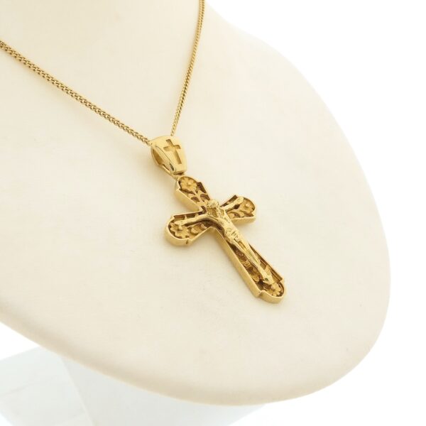 Gouden hanger van een kruis met corpus