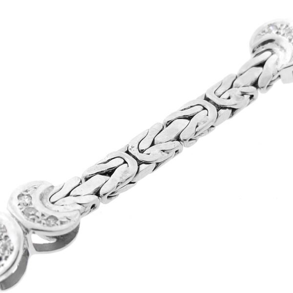 Witgouden platte koningsarmband met vaste bedels en diamant; 0,24 ct.| 19,5 cm